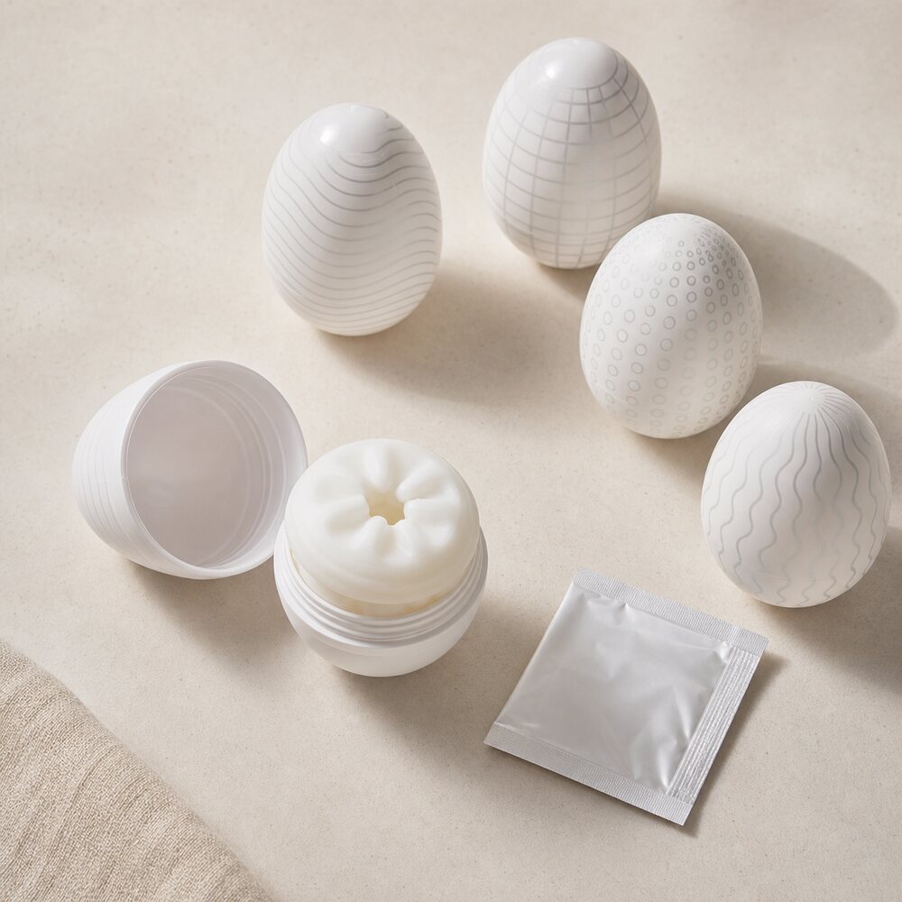 Egg-shaped disposable stroker capsules with a plain lubricant packet